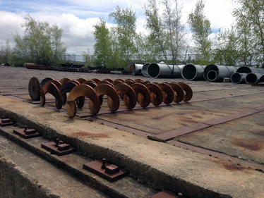 Surplus augers, pipes at harbor side