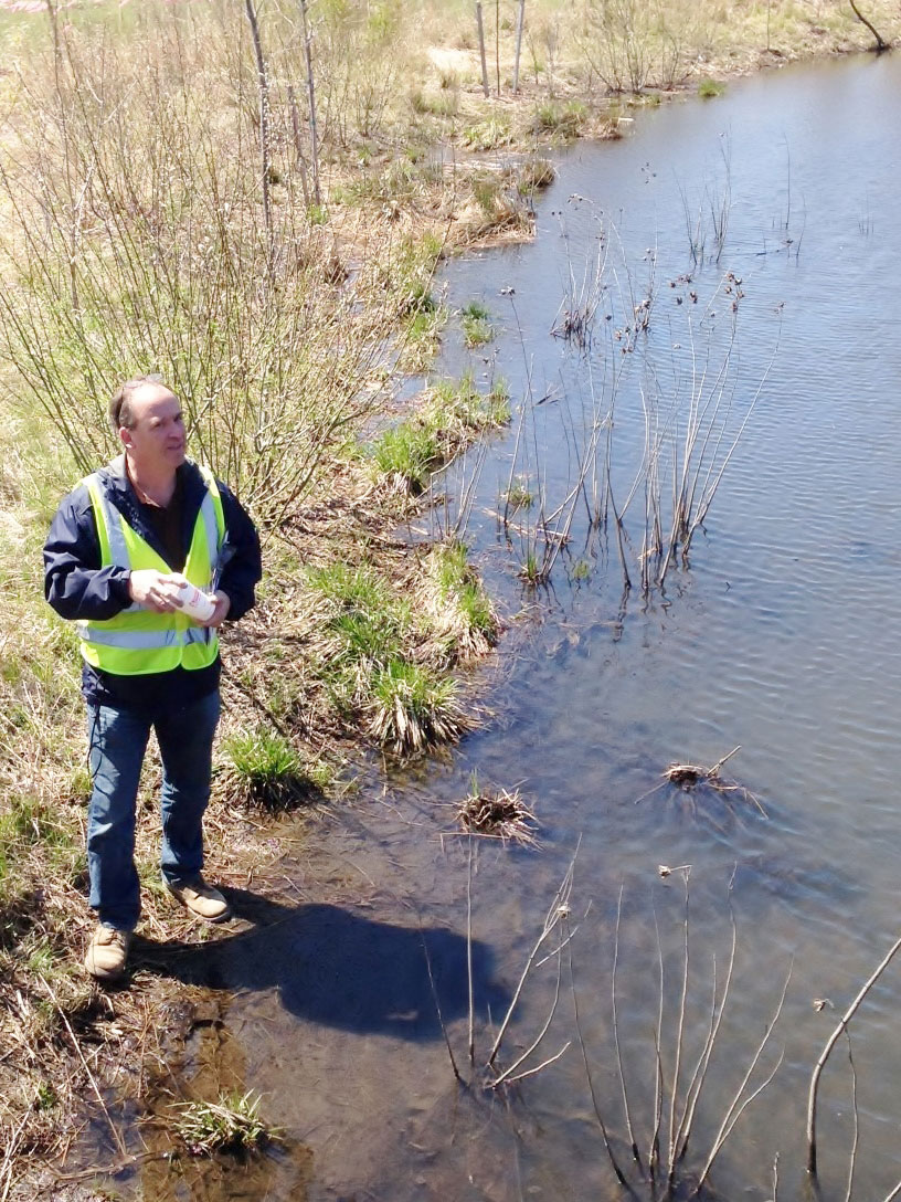 Wayne Chouinard, town engineer of Arlington and WAC member, explores the wetland.