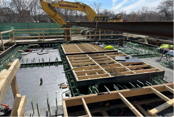 The concrete top of a pit, with wood framing built over the gaps in the roof.