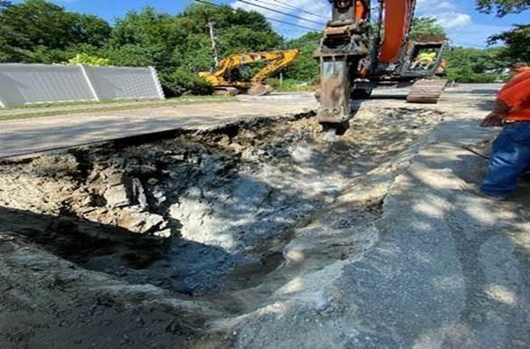 A wide and shallow pit in the road.