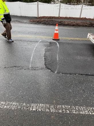 The difference between the fresh asphalt used to repair the holes dug for water main work and the existing asphalt. There is a small lip where the two meet.