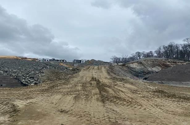 A large, dirt covered area. There are several tire tracks around the dirt.