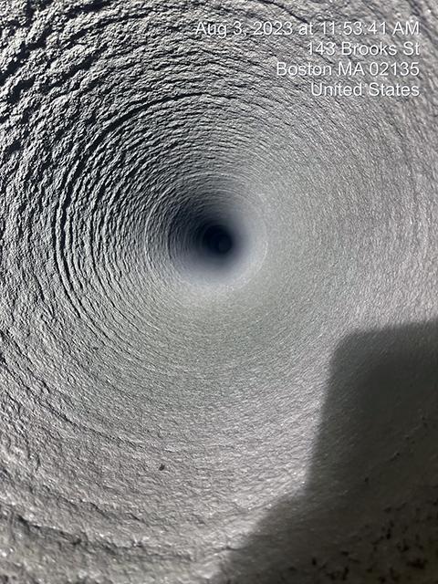 The slightly bumpy grey interior of a new pipe.