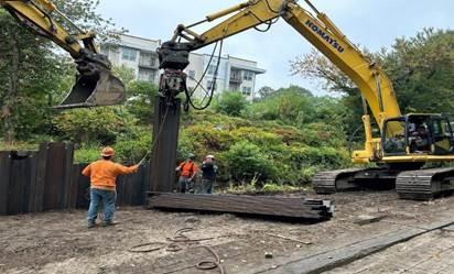 Alongside route 93 in Stoneham/Winchester area. Driving steel sheeting along stream.